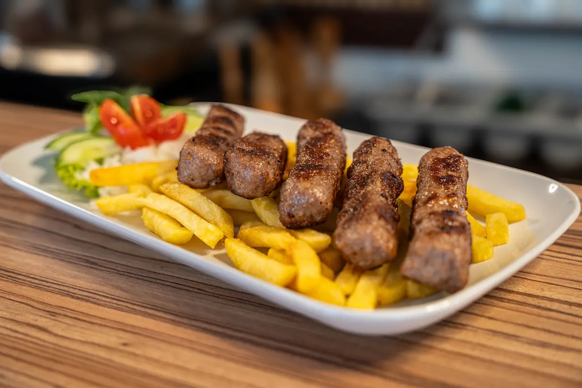 Frisch gegrillte Ćevapčići mit Pommes und Salat im Niški Merak